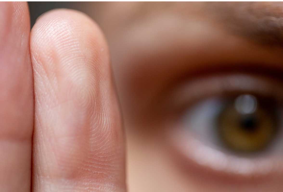 Gros plan macro sur les lignes d'un doigt et une partie d'un œil. Image représentant l'identité, la biométrie, l'identification ou la confidentialité